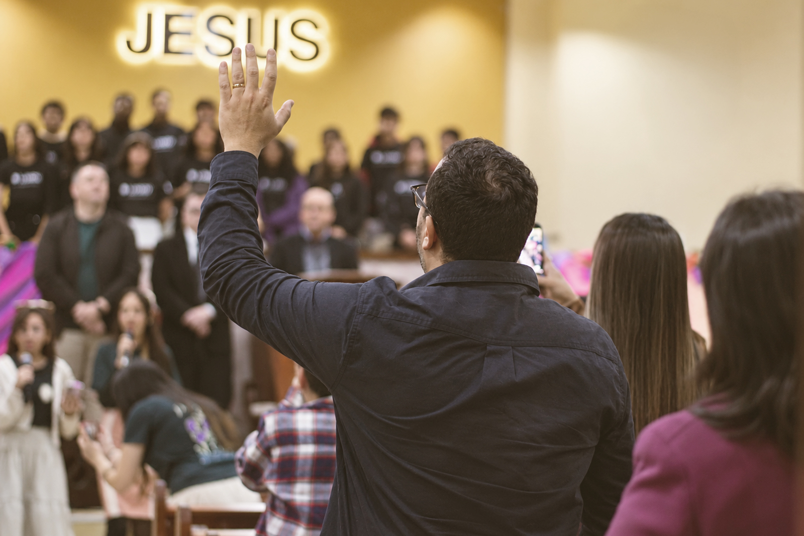 Jovens e famílias adorando em um culto, imagem ilustrativa